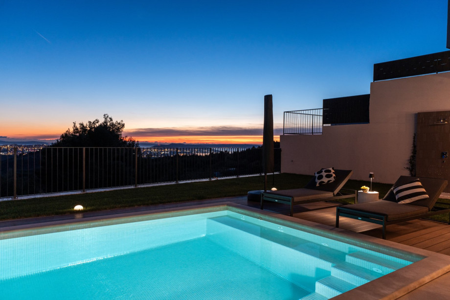 Corner view of the pool and sun loungers at dusk, overlooking the town of Split and nearby islands.