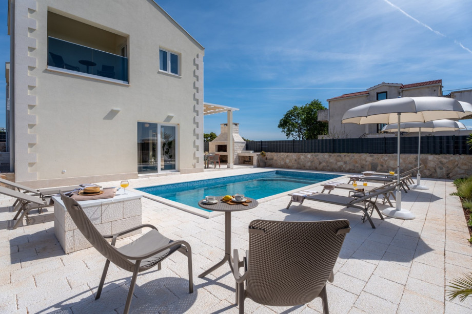 A sun place with 8 sunbeds, 3 umbrellas