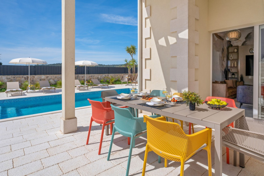 Villa Ora offers an outdoor dining area with a view of the pool area.