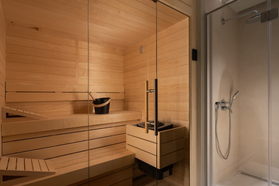 The indoor wellness facility includes a state-of-the-art Finnish sauna and a convenient adjacent walk-in shower.