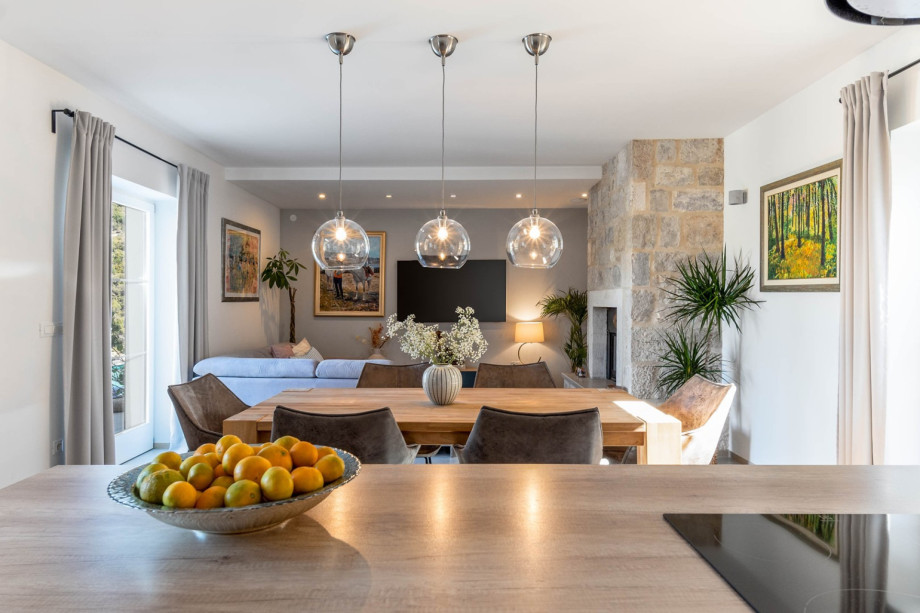 Living room with a fireplace and a dining table for 8 people.