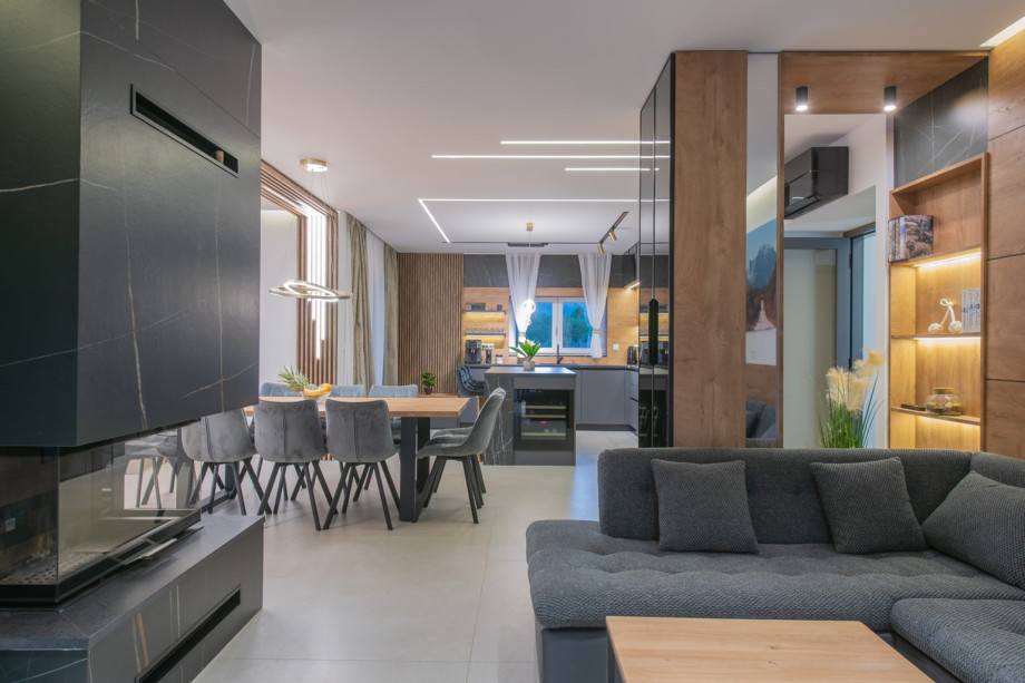 Fully air-conditioned living area with a comfortable sofa, fireplace, dining area, and equipped kitchen.