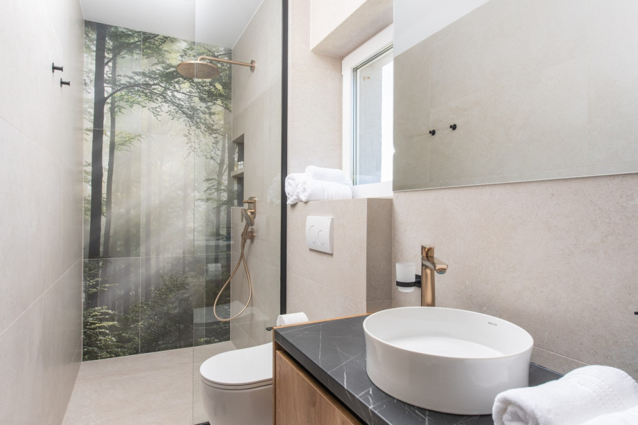 En-suite bathroom featuring a modern shower and sleek vanity, serving one of the four bedrooms.