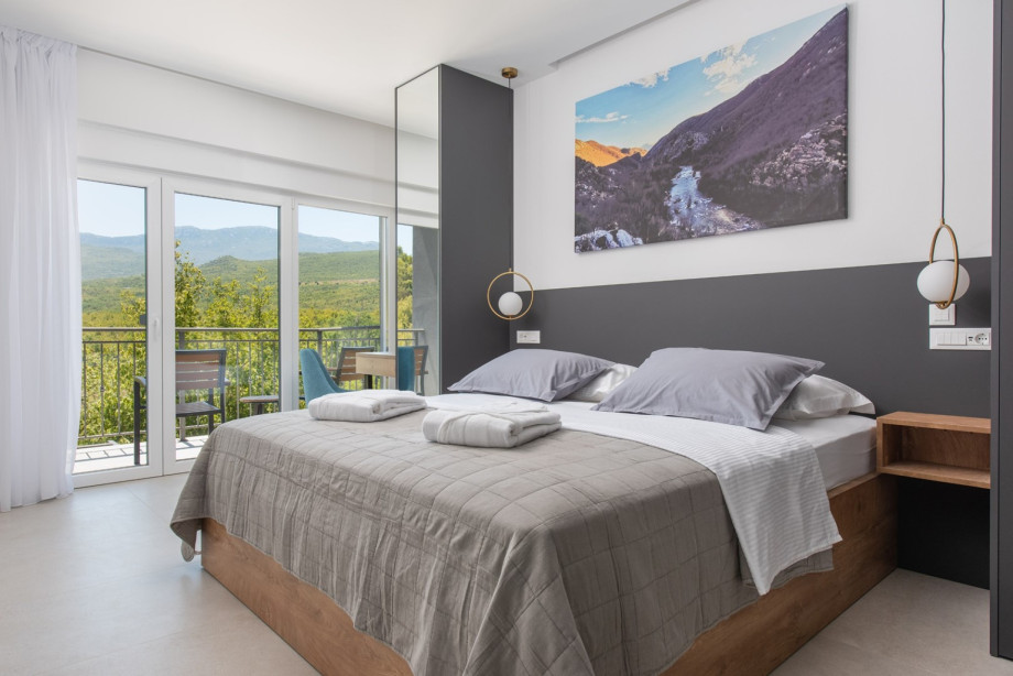 One of four en-suite bedrooms with a king-size bed, air conditioning, smart TV, and modern design.
