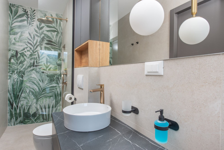 A private en-suite bathroom featuring a shower and stylish tiles.
