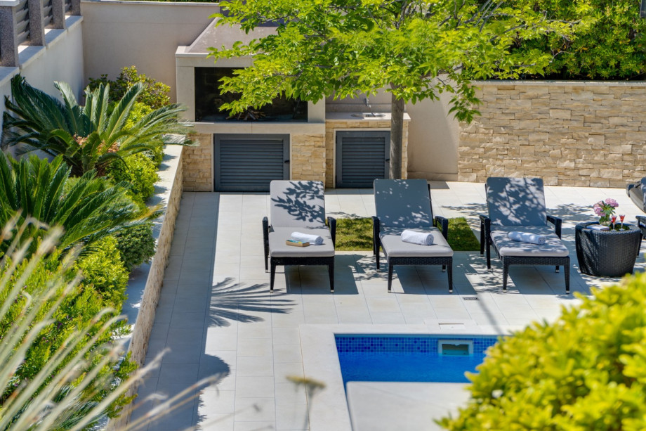 Traditional grill next to the pool and outdoor dining area