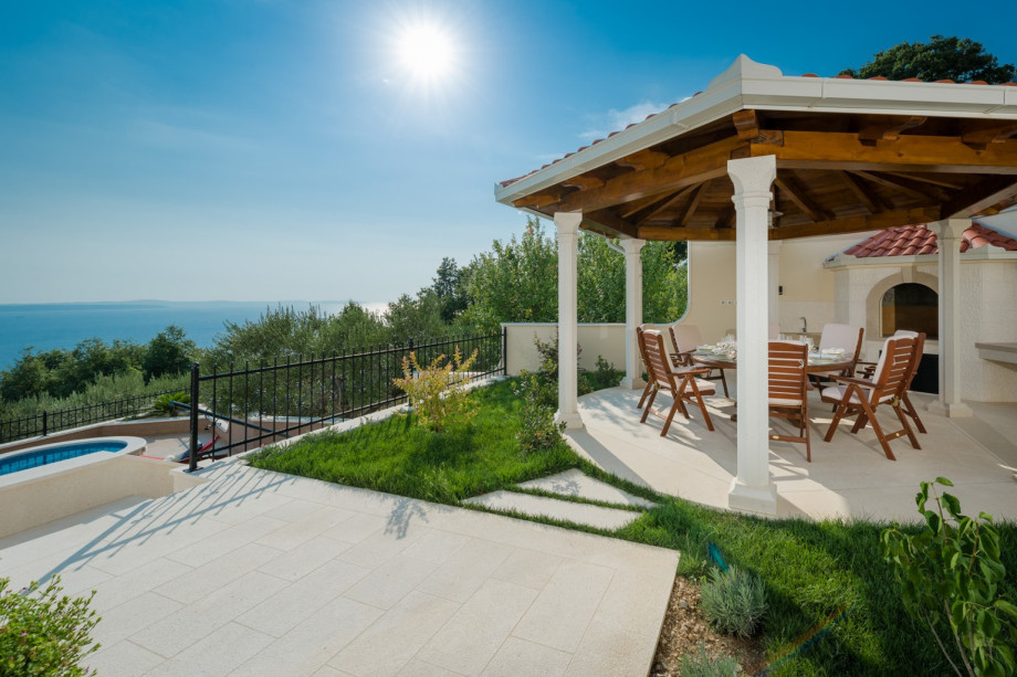 Outdoor dining area with barbecue all in living room and kitchen level (west)