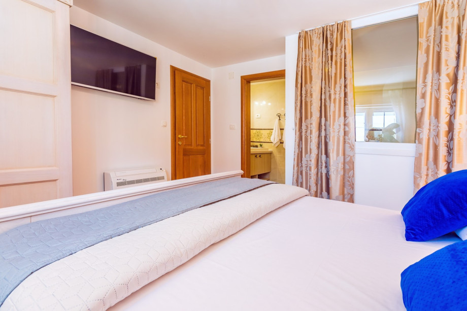 Bedroom No1. with double bed, TV, and en-suite bathroom with bathtub (pool level)