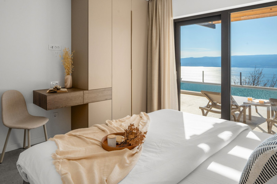 Beautifully furnished bedroom featuring a wardrobe and pool view.