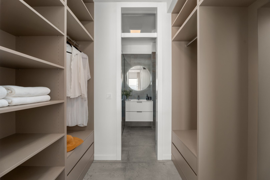 Spacious walk-in wardrobe as part of a modern and beautifully furnished bedroom.