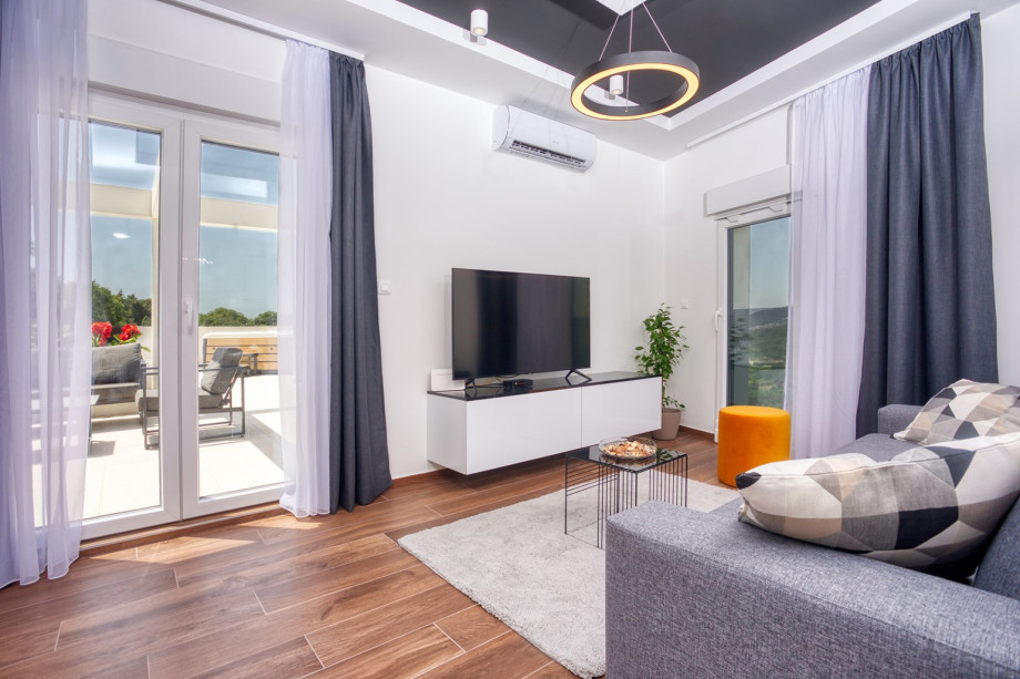 a living room with a sofa (that converts into a sofa bed), TV, free WiFi, A/C