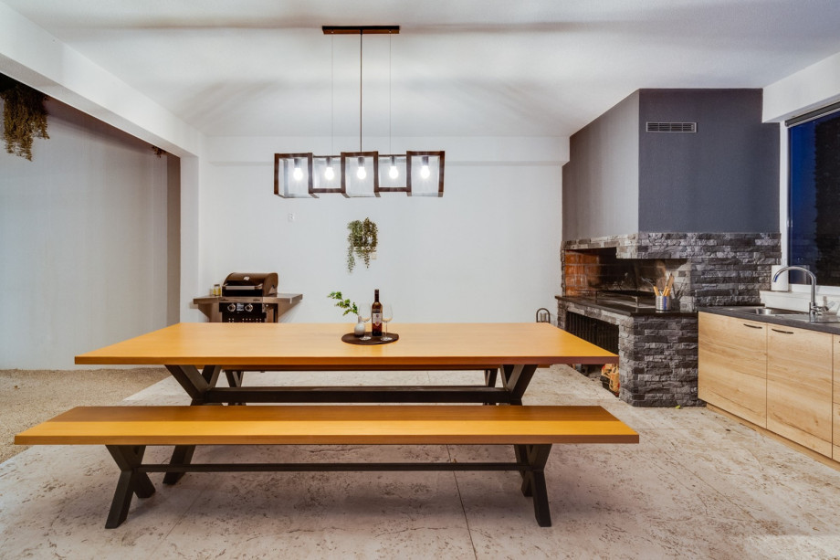 Covered, outdoor dinning area with traditional BBQ and small kitchen