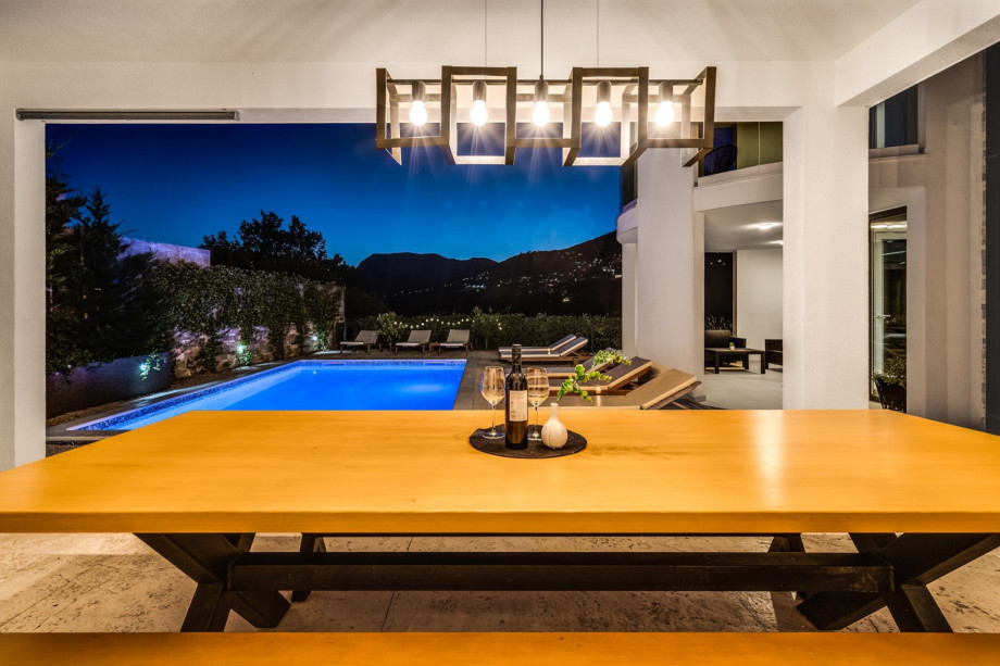 Covered, outdoor dinning area with traditional BBQ and small kitchen