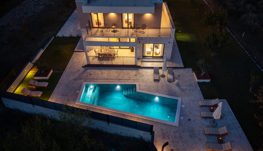 Evening ambience by the pool and covered outdoor dining area, perfect for sunset drinks and BBQ.