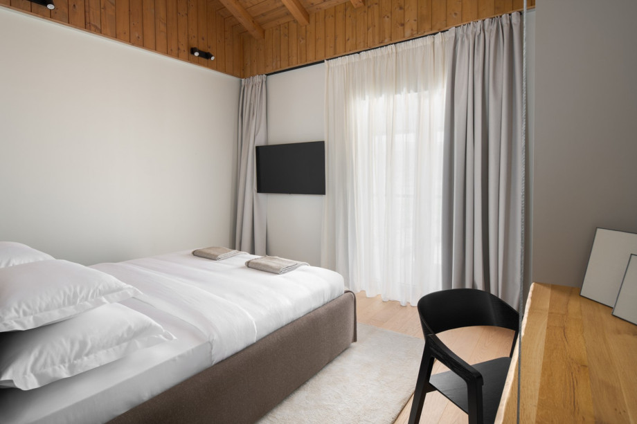 A bright, air-conditioned bedroom offering a flat-screen TV and a king-sized bed.