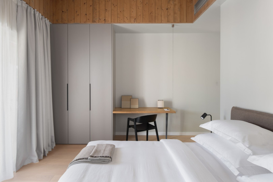 Stylish bedroom featuring a desk area and integrated storage, blending modern elegance with comfort.