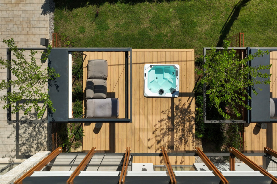 Aerial view of the private terrace featuring a relaxing whirlpool and a lounge area on a wooden deck.