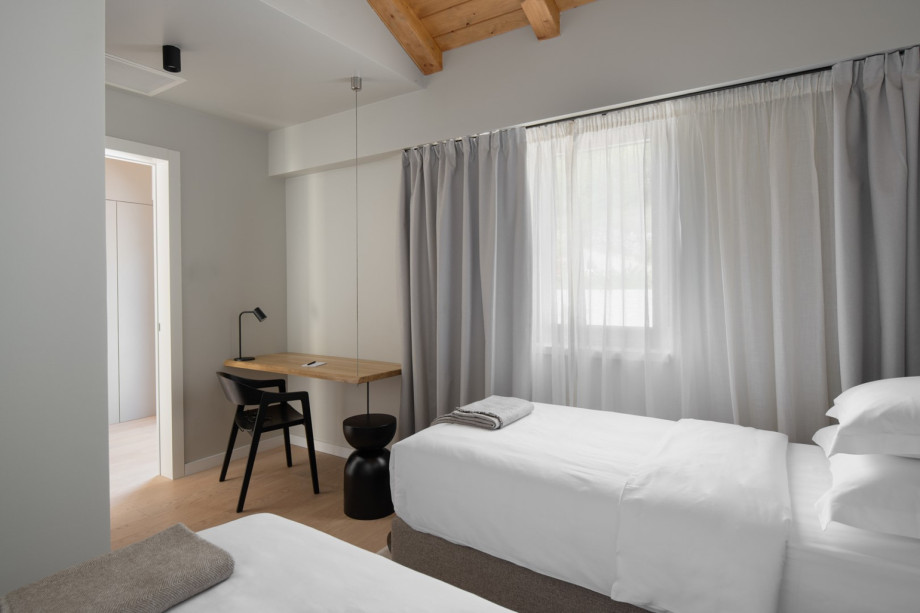 Modern twin bedroom at Villa Terra Moro featuring a minimalist workspace and stylish, neutral decor.