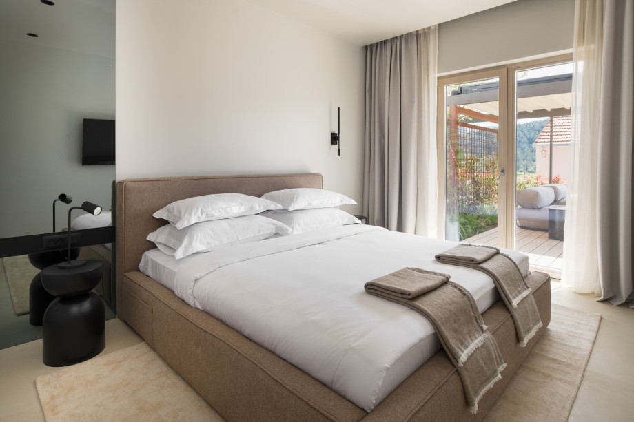 Cosy bedroom with direct access to a private terrace and outdoor lounge area.