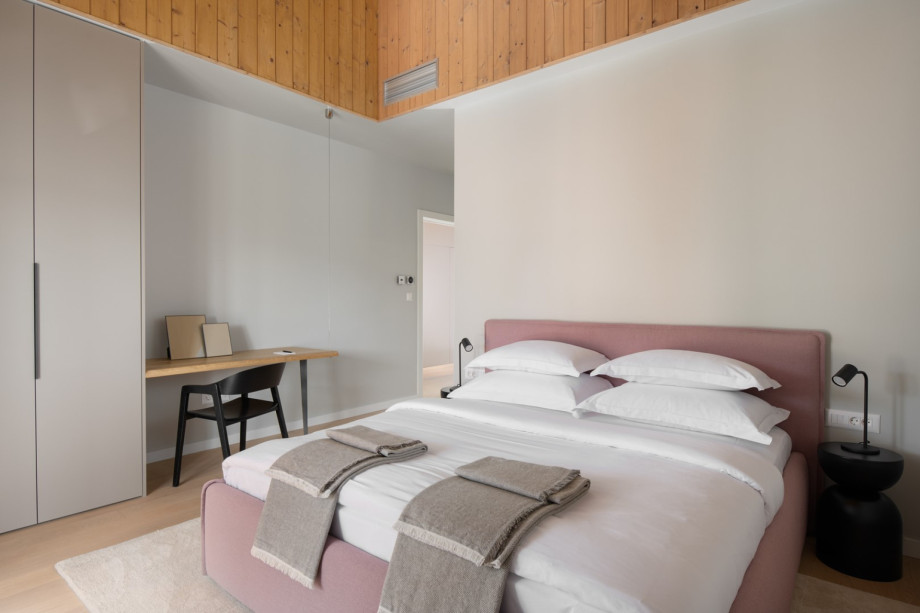 A bright room features a king-size bed and offers soft, neutral tones for a restful stay.