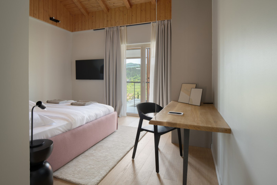 A beautifully appointed bedroom featuring a private balcony that offers stunning views of the surrounding landscape.