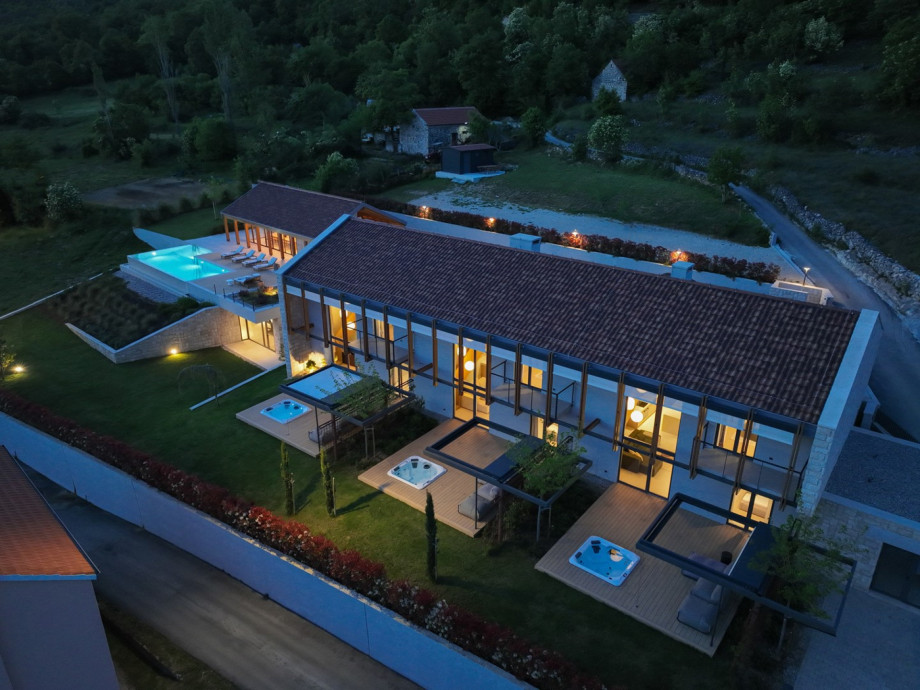 A stunning bird's-eye view of the entire estate, highlighting the heated pool and meticulously organized grounds.