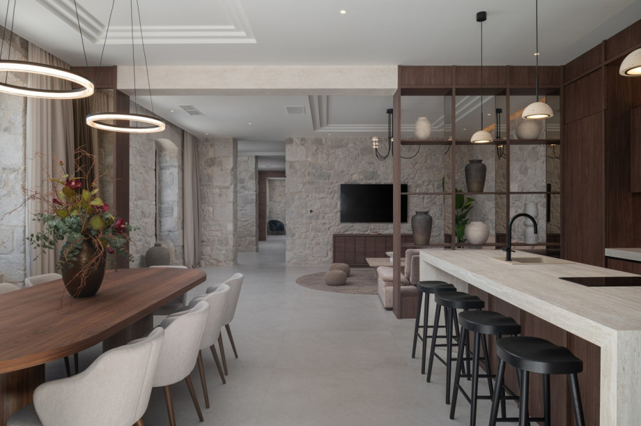 The open-plan ground floor includes a gourmet kitchen with a large island and stylish dining table.