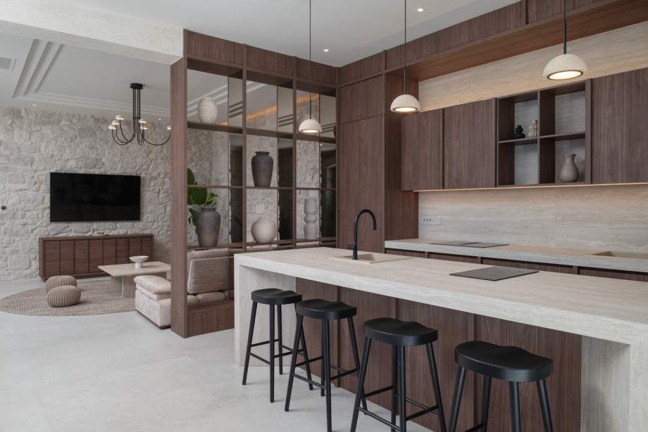 The gourmet kitchen is fully equipped with modern appliances, a kitchen island, and four stools.