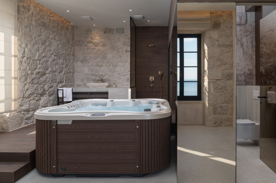 Relax in the spa zone's hot tub, located near the Finnish sauna and a separate shower area.