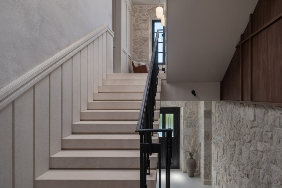 Natural stone and wood highlight the classic Mediterranean style of the villa's high-ceilinged staircase.