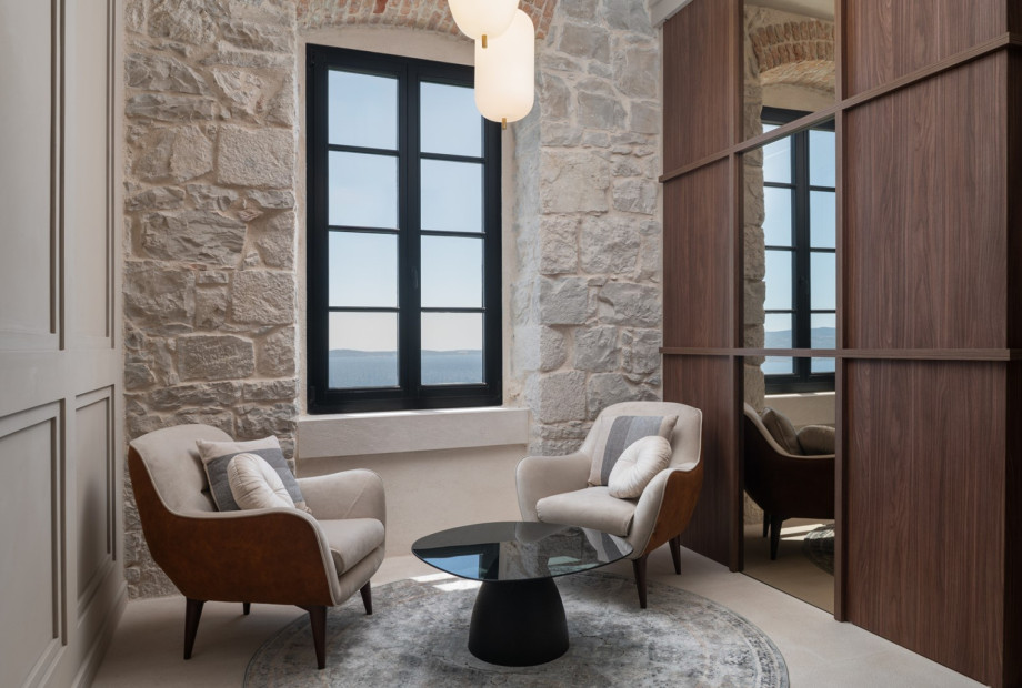 Living area offer stylish custom furnishings and natural light through large windows.