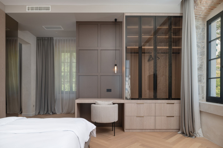The stylish room includes a glass-fronted wardrobe and air conditioning for a comfortable stay.