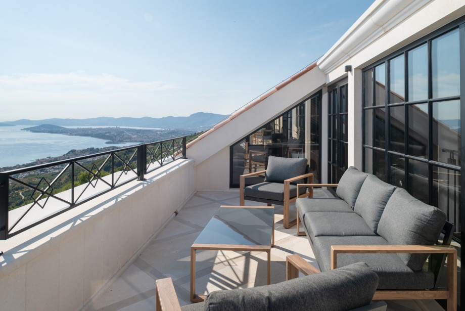 Enjoy the fresh Mediterranean air from the fenced balcony with comfortable lounge seating.