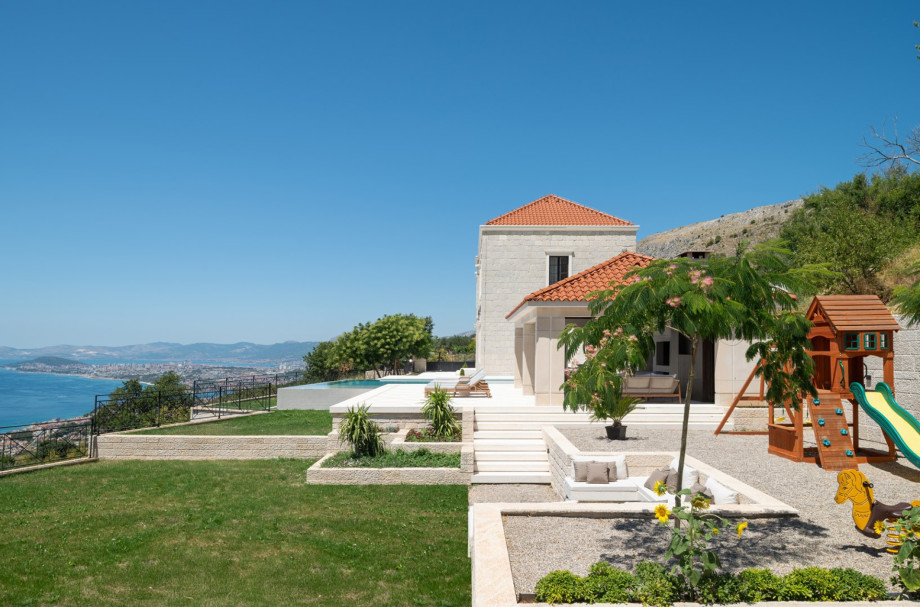The estate features a children's play frame with a slide and a heated infinity pool.