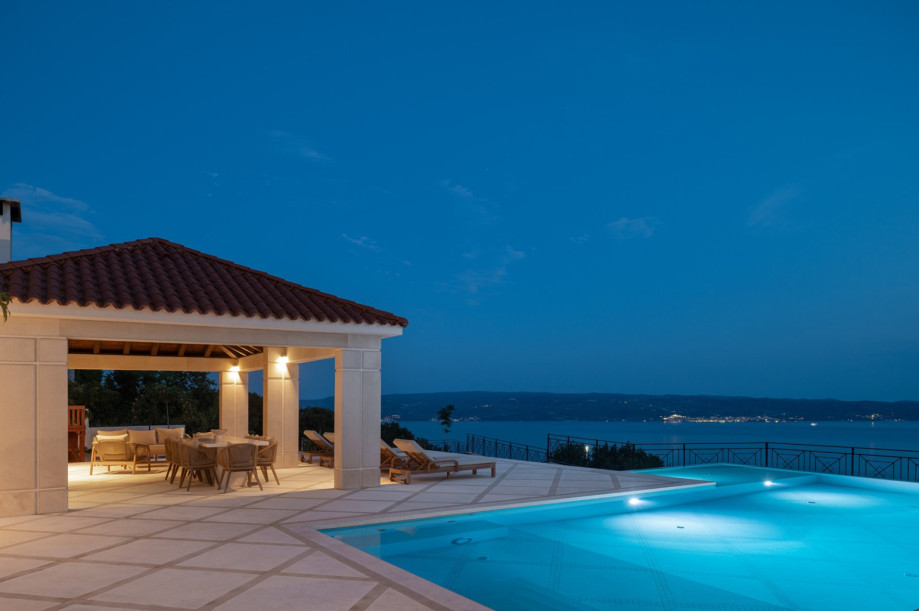 Dine al fresco in the covered outdoor area featuring a barbecue and beautiful sea views.