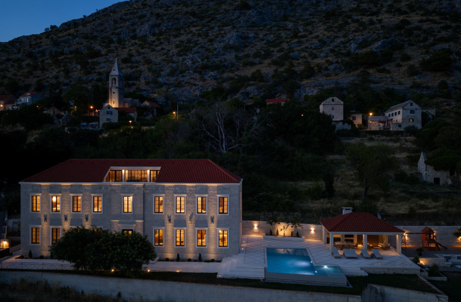 Royal Villa Petra is a 500 m2 retreat featuring a heated infinity pool and traditional stone architecture.