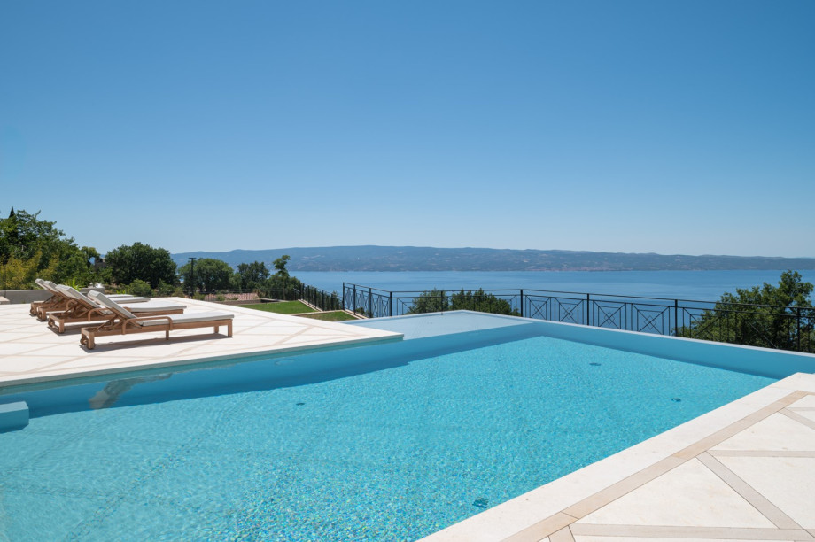 Enjoy the private sun deck equipped with lounge chairs, ideal for soaking up the sun by the infinity pool.