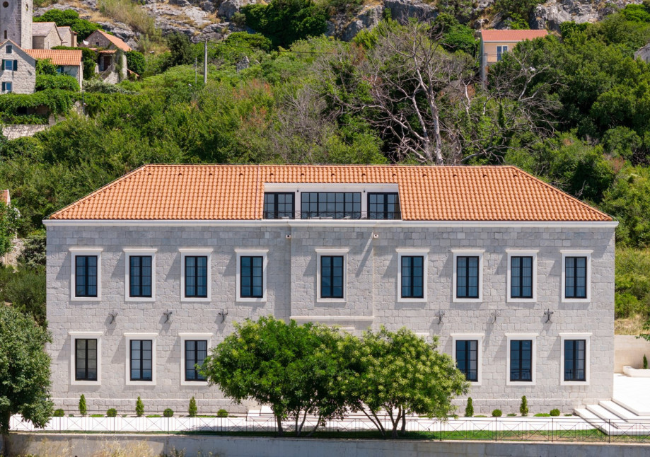 Royal Villa Petra features three distinct living areas styled with custom furnishings and large windows.