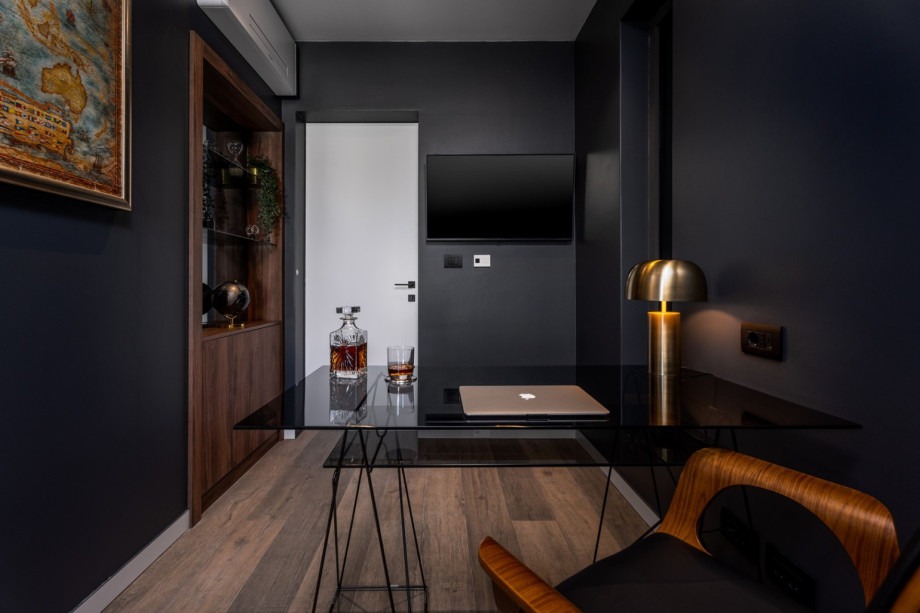 The First floor offers a stylish office with an office table, a chair, and a TV.