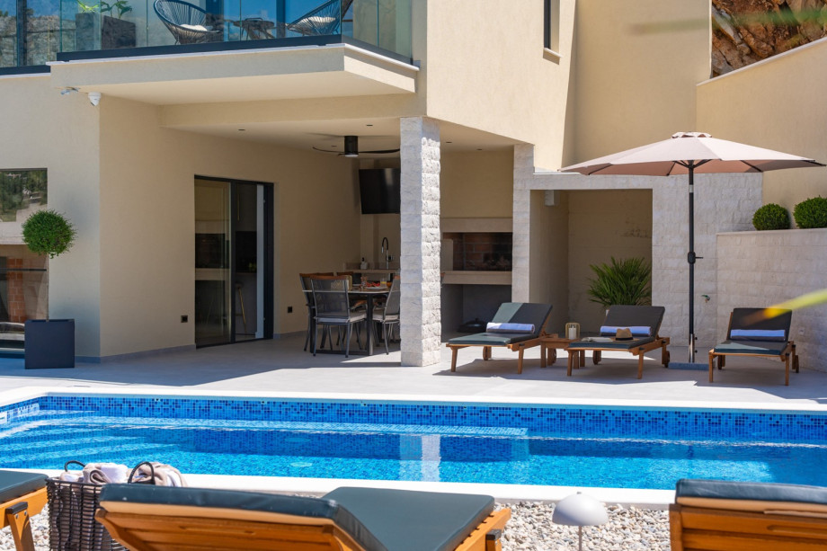 Sparkling swimming pool measuring 8,2 m by 4 m with large sunbathing area