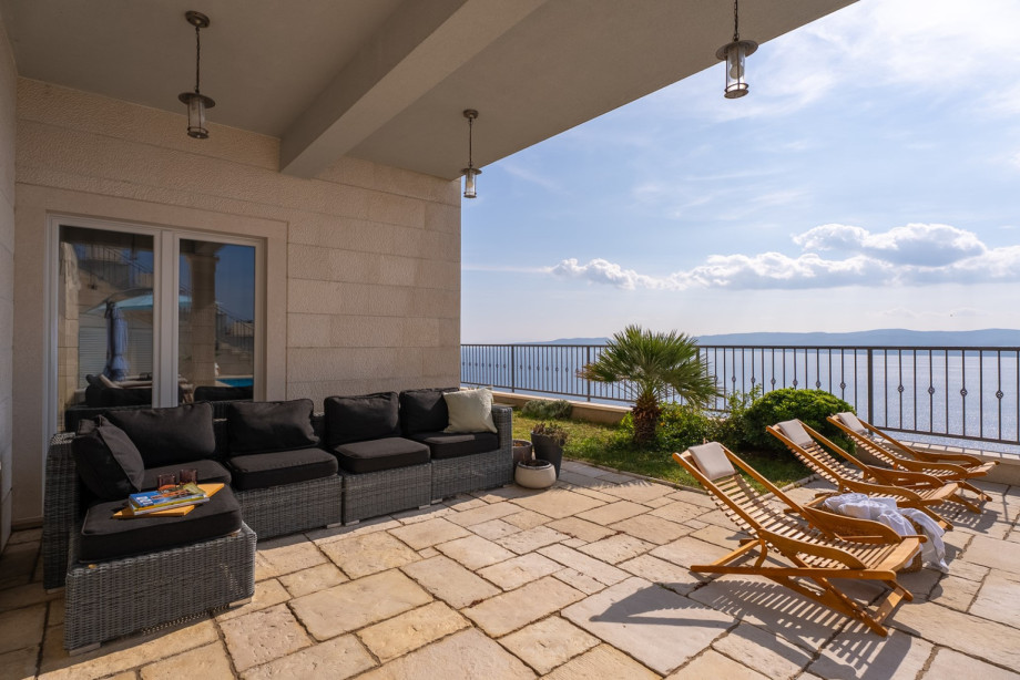 The outdoor living area is seamlessly connected to the sun terrace, allowing guests to choose between relaxing in the shade or soaking up the sun
