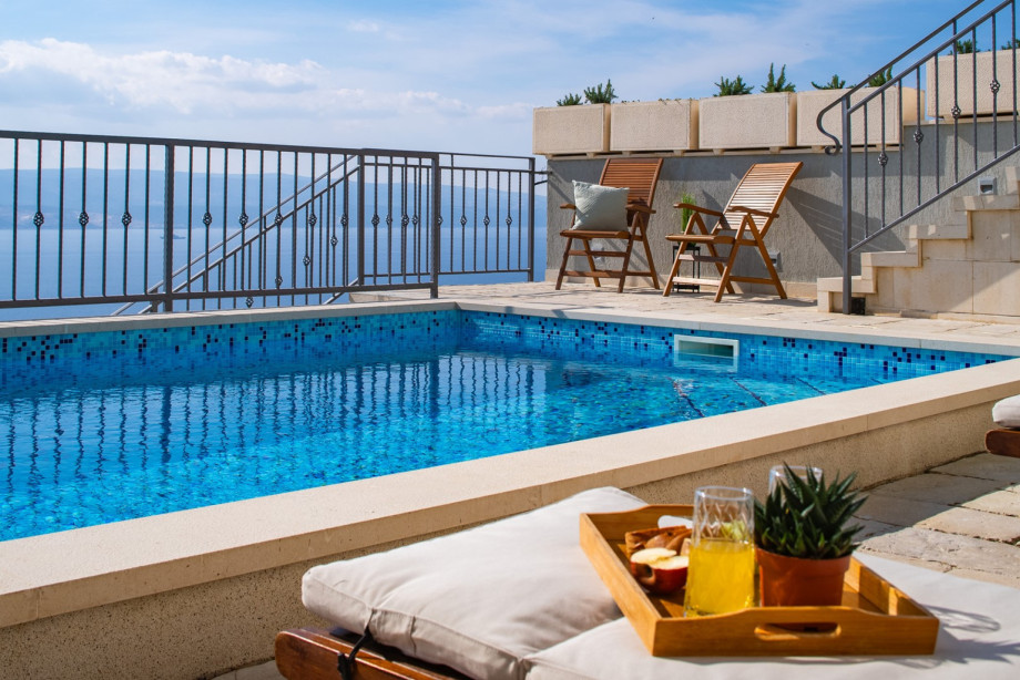 Enjoy the wooden chairs on the terrace, which provide an unobstructed view over the pool's edge to the sea
