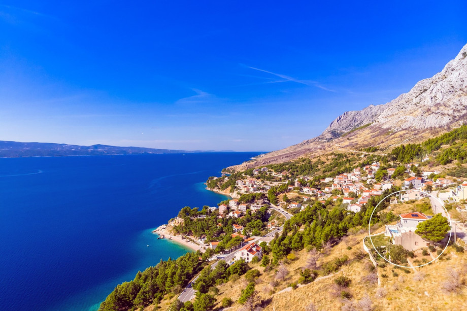 This aerial view highlights the coastline and the villa's location, marked by a circle, emphasizing its distance and privacy