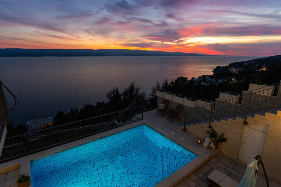 The illuminated pool and terrace capture the breathtaking colors of a Dalmatian sunset, turning the evening into a spectacular experience