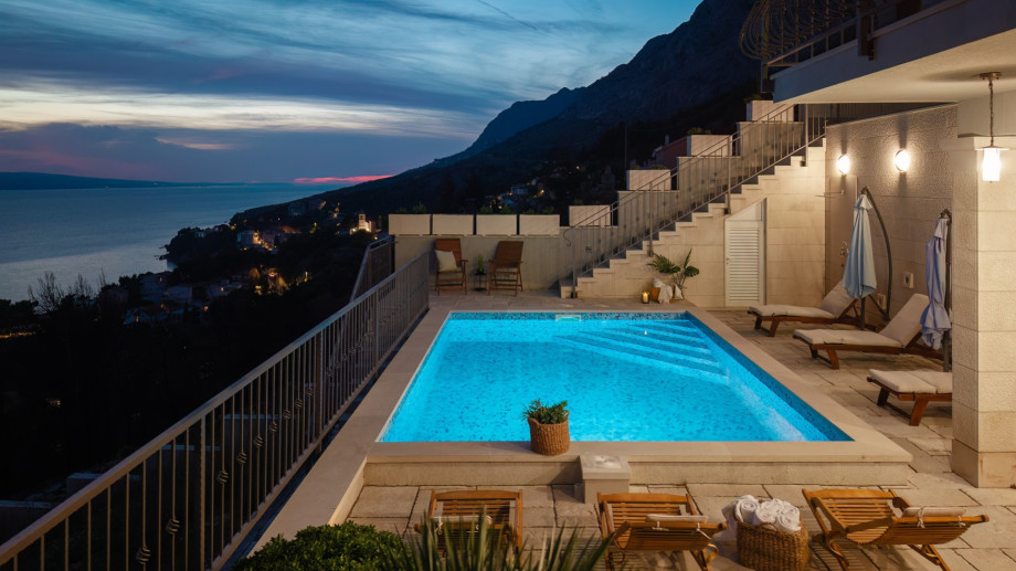 The pool and terrace, beautifully illuminated at twilight, provide a magical and romantic atmosphere