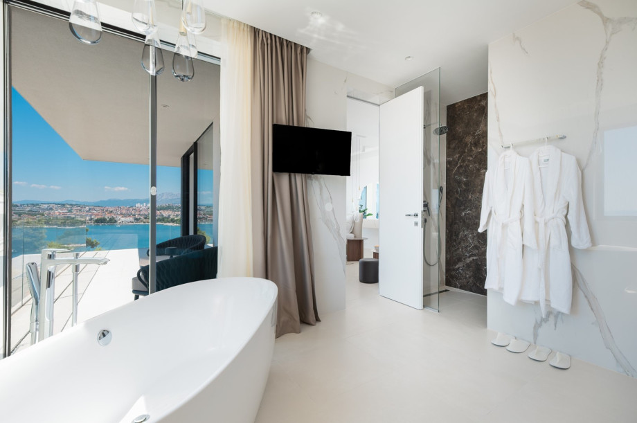 An en-suite bathroom with a bathtub, a shower, a sink, and a toilet