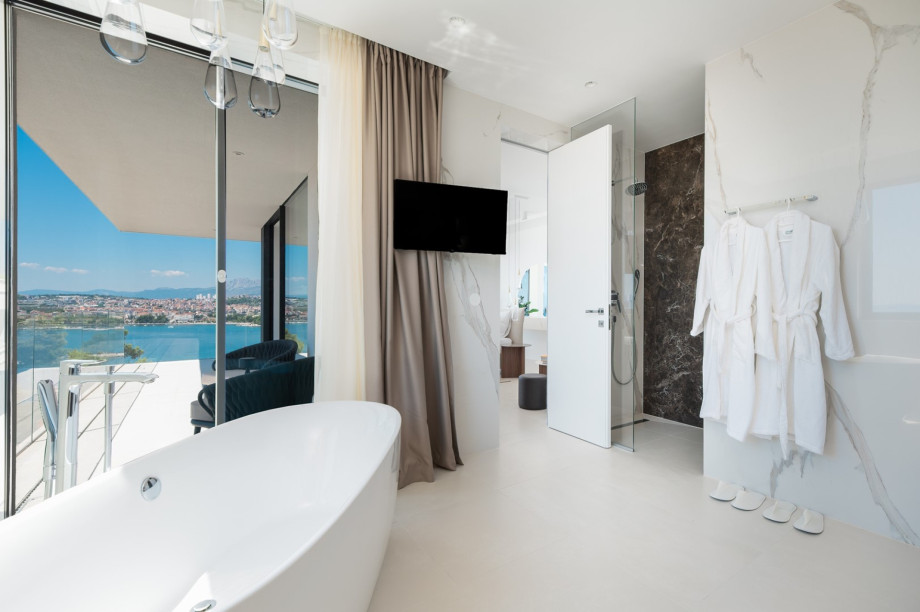 An en-suite bathroom with a bathtub, a shower, a sink, and a toilet