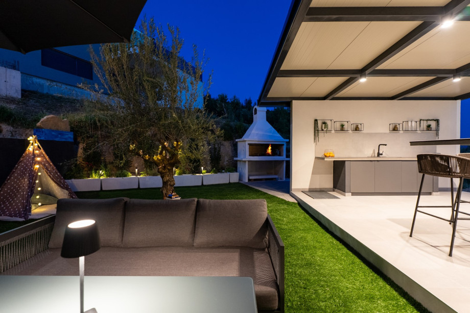 Außenbereich mit traditionellem Holz- und Holzkohlegrill, ideal für abendliche Zusammenkünfte