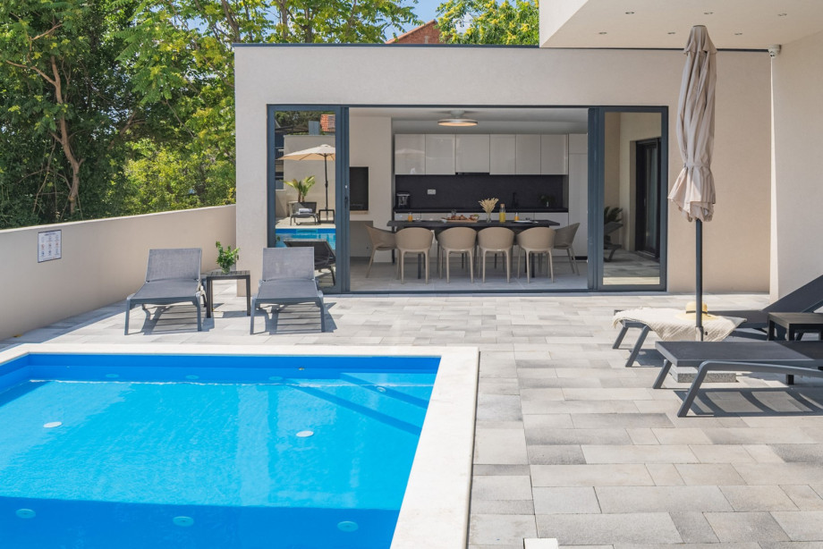 A covered dining area beckons guests to enjoy al fresco meals in style