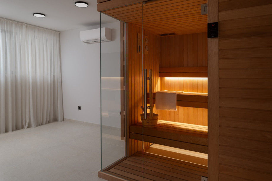 There’s also a dedicated spa room featuring a Finnish sauna, exercise bike, a TV, and shower, along with laundry facilities that include a washing machine and dryer.